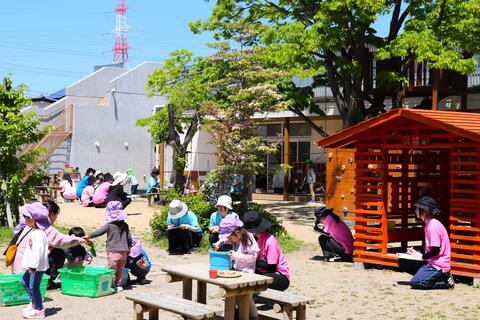 すがすがしい晴天の下、砂や水にふれて遊ぶ3歳児の姿