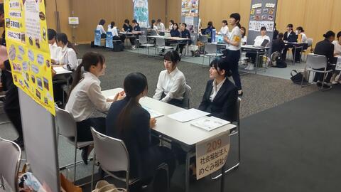 法人のブースで話を聞く学生